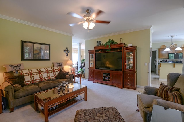 carpeted living room with decorative columns, crown molding, and ceiling fan with notable chandelier