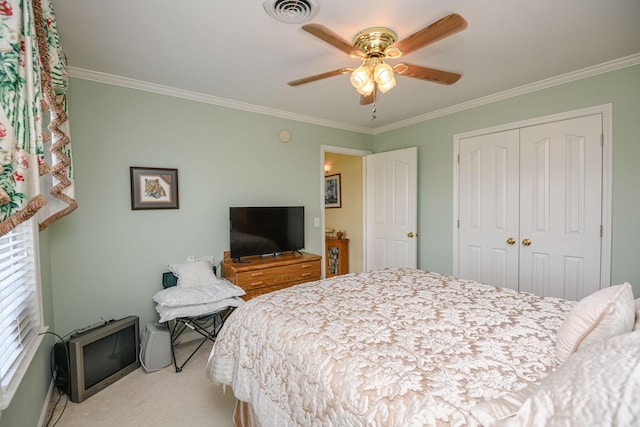 bedroom with crown molding, light colored carpet, ceiling fan, and a closet