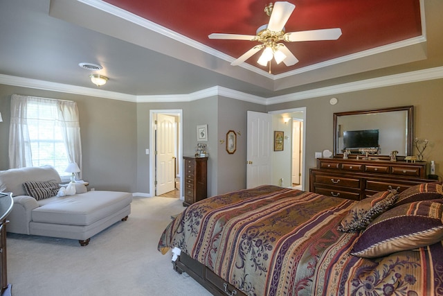 bedroom with crown molding, light colored carpet, and a raised ceiling