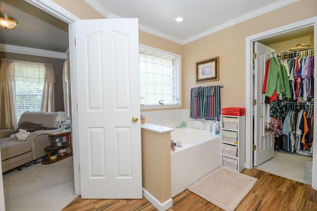 bathroom featuring a washtub, hardwood / wood-style floors, and crown molding