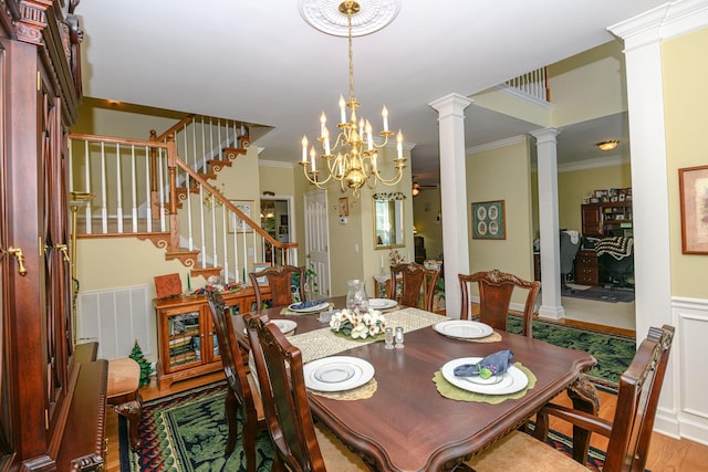 dining area with a notable chandelier, ornamental molding, and decorative columns