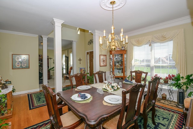 dining room featuring hardwood / wood-style floors, ornamental molding, decorative columns, and a chandelier