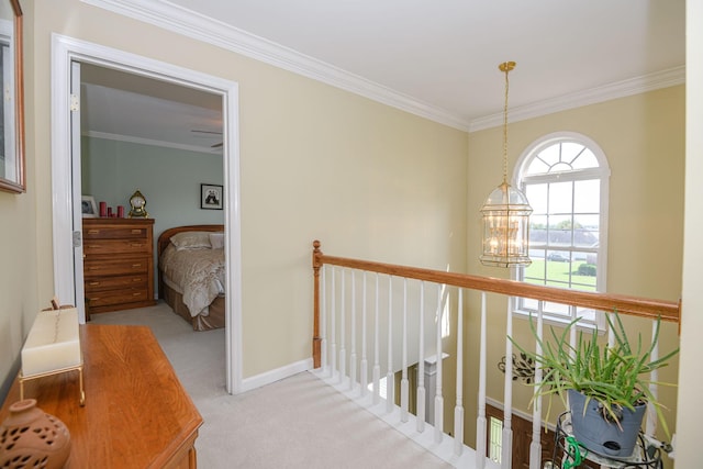 hallway with crown molding, light carpet, and a chandelier