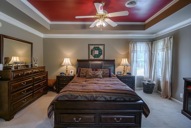 carpeted bedroom with crown molding, ceiling fan, and a raised ceiling