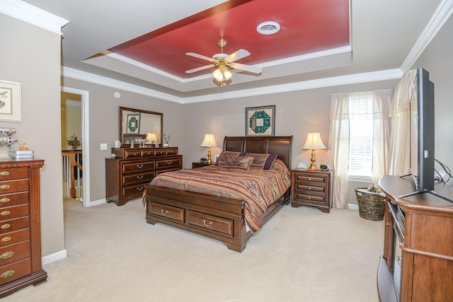 bedroom with light carpet, a tray ceiling, ornamental molding, and ceiling fan