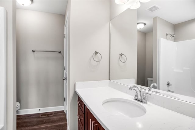 full bathroom featuring vanity, hardwood / wood-style flooring, toilet, and shower / washtub combination