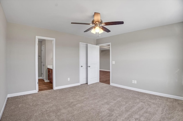 unfurnished bedroom featuring carpet floors, ensuite bathroom, and ceiling fan