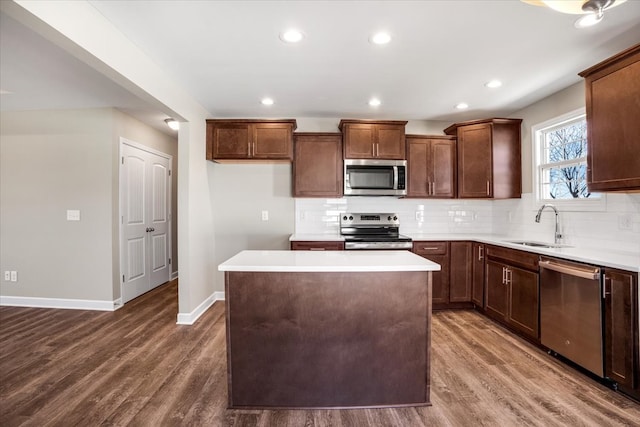 kitchen with a center island, stainless steel appliances, dark hardwood / wood-style floors, and sink