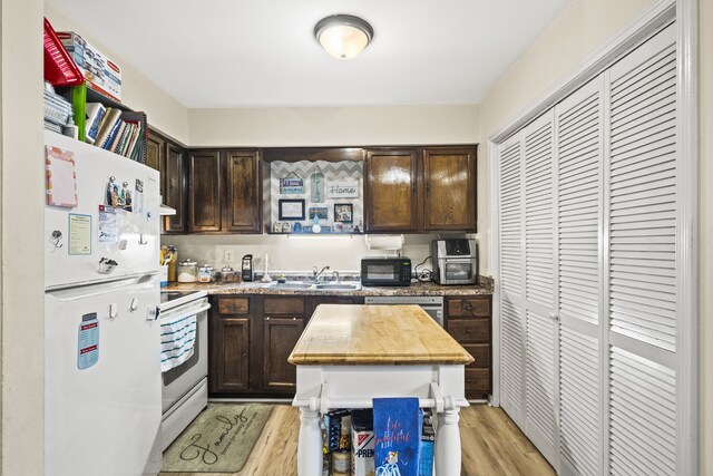 kitchen with white appliances, light hardwood / wood-style floors, dark brown cabinetry, and sink