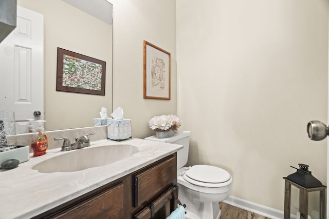 bathroom with hardwood / wood-style flooring, vanity, and toilet