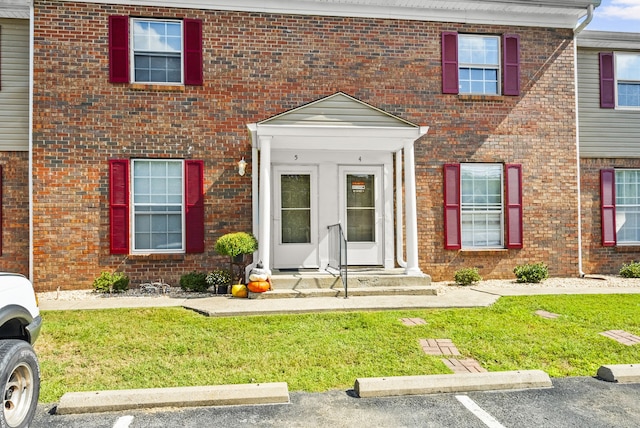 view of exterior entry featuring a yard