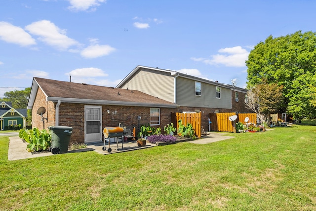 back of house with a patio and a lawn