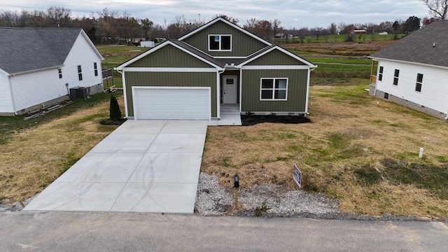 view of front of property featuring central air condition unit, a front lawn, and a garage