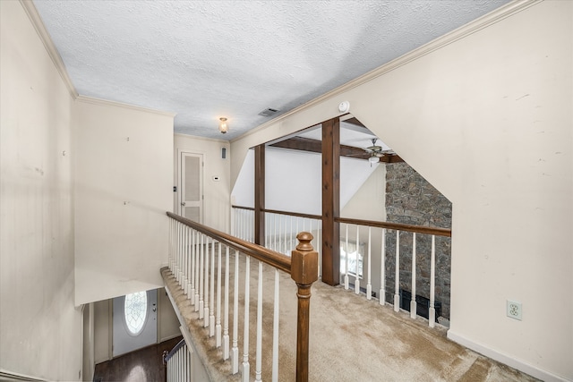 hall featuring lofted ceiling, light colored carpet, a textured ceiling, and crown molding