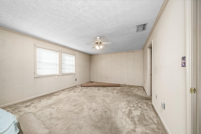 unfurnished bedroom with a textured ceiling, ornamental molding, light carpet, and ceiling fan