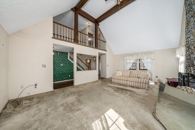 unfurnished living room featuring beamed ceiling, a textured ceiling, high vaulted ceiling, and carpet