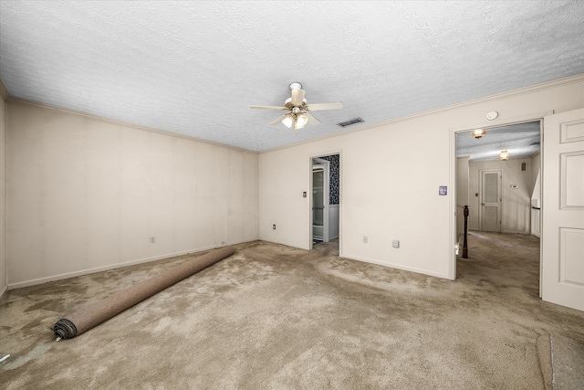 spare room featuring ceiling fan, a textured ceiling, light carpet, and crown molding