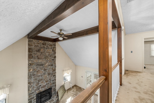 interior space with a textured ceiling, carpet flooring, and vaulted ceiling with beams