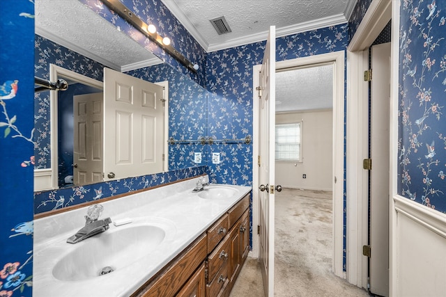 bathroom with vanity, a textured ceiling, and ornamental molding