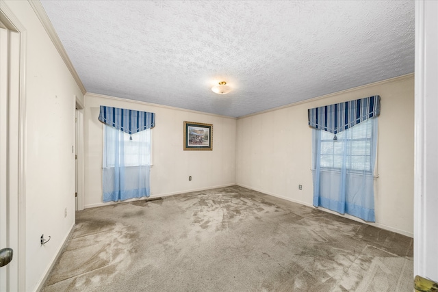 spare room with a textured ceiling, carpet flooring, and ornamental molding