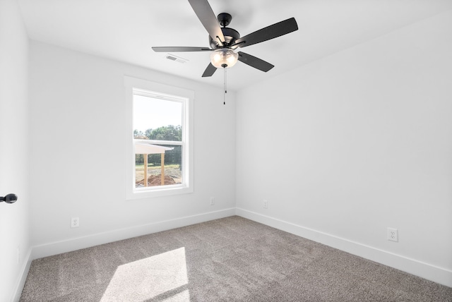 empty room featuring ceiling fan and carpet