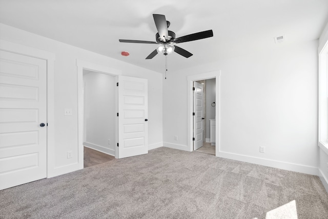 unfurnished bedroom with light carpet, ceiling fan, and connected bathroom