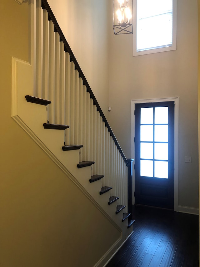 entryway featuring dark wood-type flooring, an inviting chandelier, and a healthy amount of sunlight