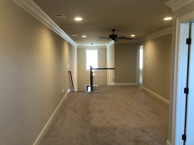 corridor with crown molding and carpet