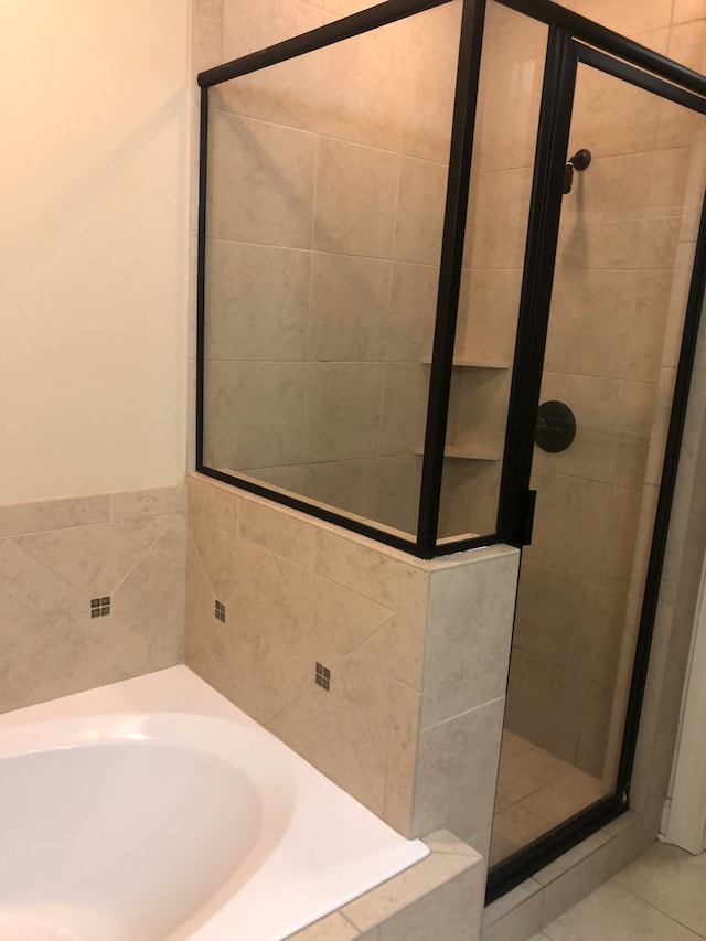 bathroom featuring tile patterned floors and independent shower and bath