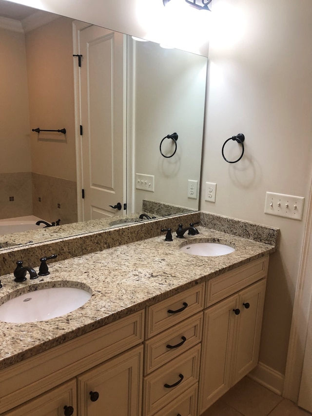 bathroom featuring tile patterned flooring, a washtub, and vanity