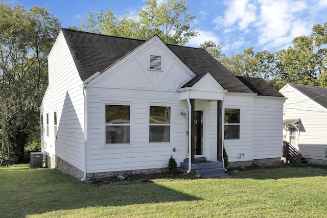 view of front of property featuring cooling unit and a front yard