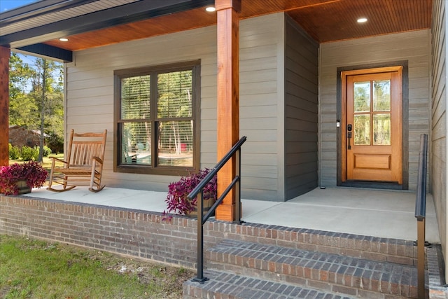 view of exterior entry featuring covered porch