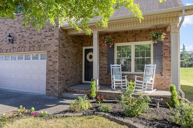 doorway to property with covered porch and a garage