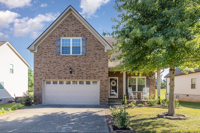 view of front of house featuring a garage, a front yard, and covered porch