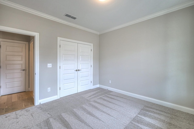 unfurnished bedroom with crown molding, carpet floors, and a closet