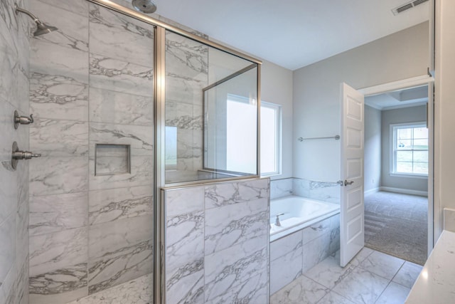 bathroom featuring shower with separate bathtub