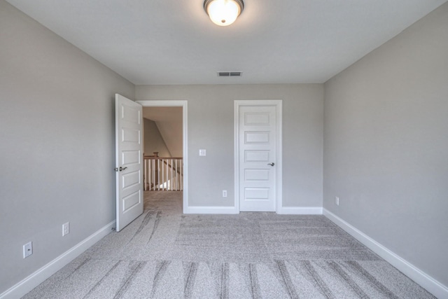 unfurnished bedroom featuring light colored carpet and a closet