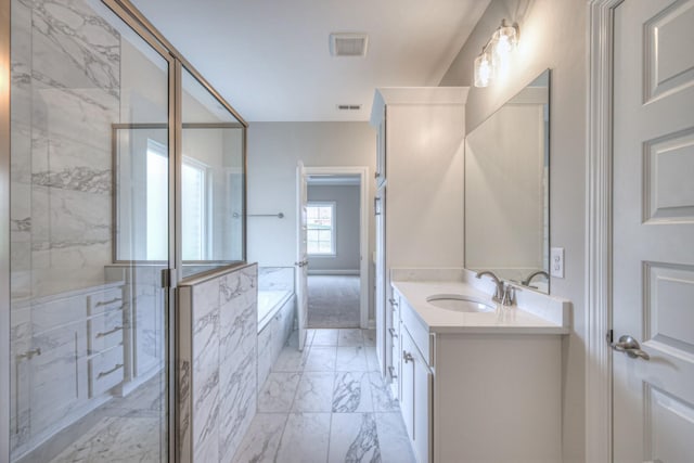 bathroom with vanity and shower with separate bathtub