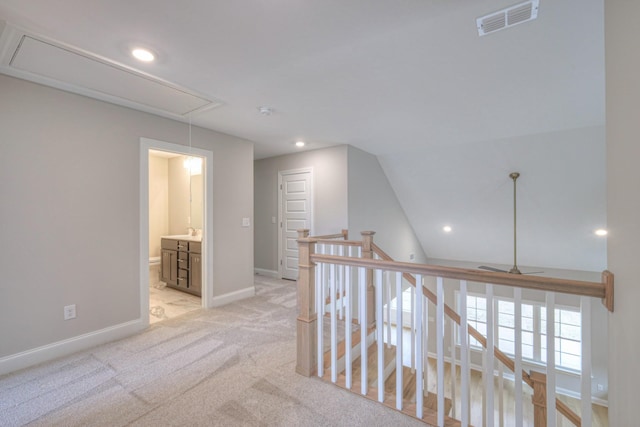 hall with lofted ceiling and light colored carpet