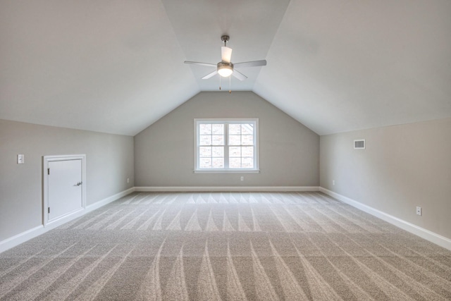 additional living space featuring lofted ceiling, light carpet, and ceiling fan