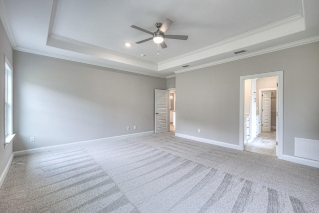 carpeted spare room with ornamental molding, a raised ceiling, and a wealth of natural light