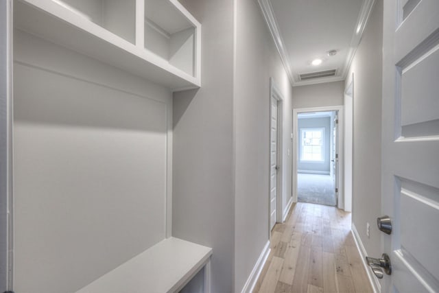 mudroom with crown molding and light wood-type flooring