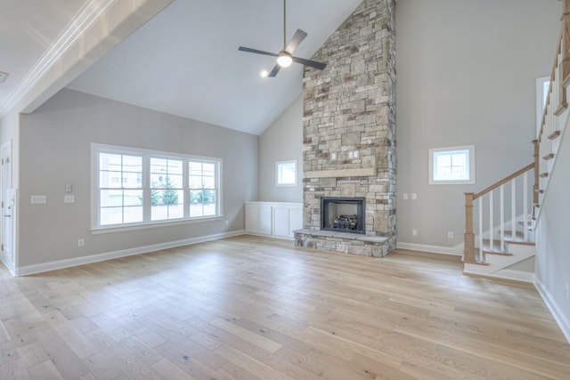 unfurnished living room with light hardwood / wood-style flooring, a fireplace, high vaulted ceiling, and ceiling fan