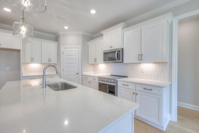 kitchen with white cabinetry, sink, stainless steel appliances, and light stone countertops