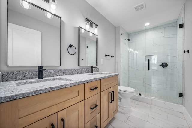 bathroom featuring toilet, a shower with shower door, and vanity