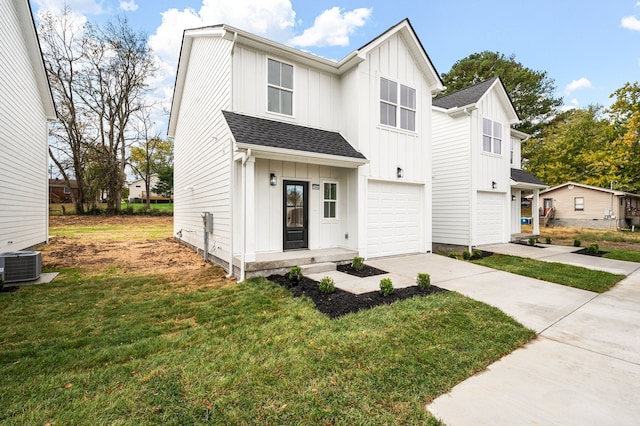 view of front of house featuring a front yard, a garage, and central AC unit