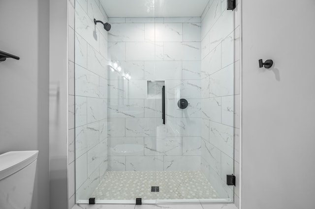 bathroom with toilet and a shower with shower door