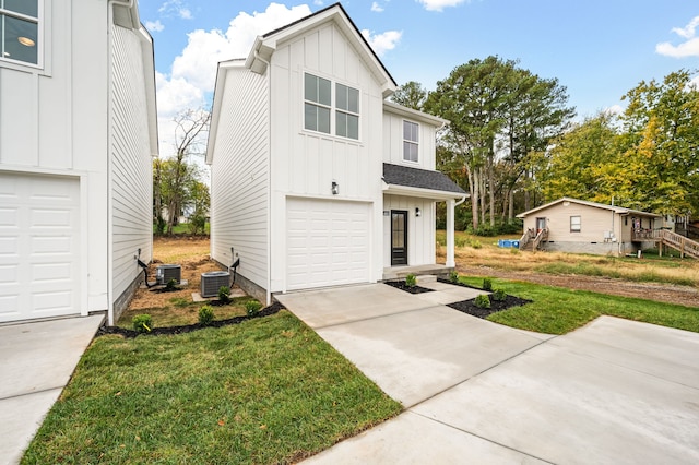 view of front of property featuring central air condition unit, a front yard, and a garage