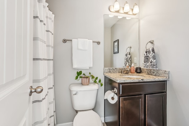 bathroom featuring vanity, walk in shower, and toilet