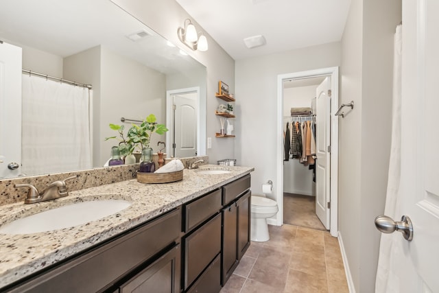 bathroom featuring toilet, tile patterned flooring, and vanity